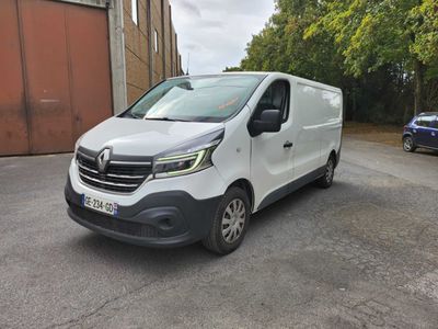 une camionnette blanche garée sur un parking à côté d'un bâtiment