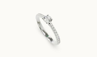 a diamond and emerald ring on a white background