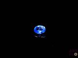 a close up of a blue diamond on a black surface