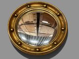 a gold porthole mirror on the wall of a building
