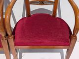 a red chair with a wooden frame and a red cushion
