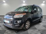 La petite camionnette noire est garée sur un sol en carrelage à damier.