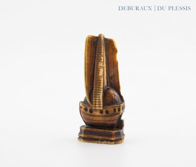 une petite statue représentant un bateau posée sur une surface blanche