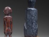 two wooden sculptures of a man and a woman sitting on a table