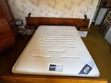 a mattress on the bed in the corner of the room