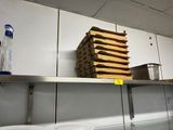 a stack of pizza boxes sitting on a shelf in a kitchen