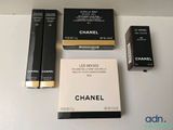 three boxes of chanel makeup on a table with a box of lipstick