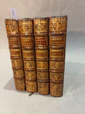 un ensemble de cinq livres anciens aux couvertures dorées sur fond blanc
