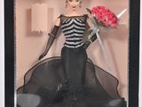 une poupée Barbie vêtue d'une robe noire et blanche, tenant un bouquet de fleurs