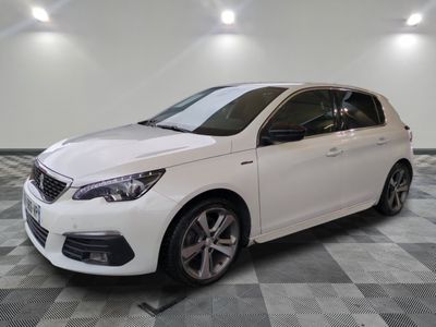 la voiture blanche est garée sur un sol en damier dans le garage