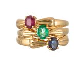 une image représentant une bague en or sertie de trois pierres de couleurs différentes