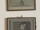 three framed pictures of women in old fashions hang on a wall