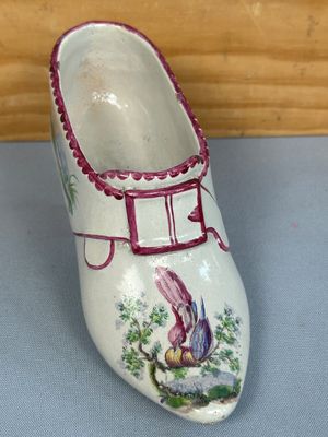 une chaussure blanche ornée d'un oiseau sur un fond bleu