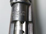 an old gun with a wooden handle on a white wall
