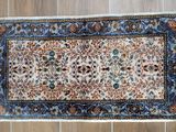 an image of a rug on a wooden floor next to a remote control
