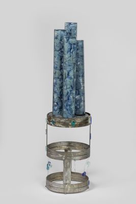une pile de bougies bleues posée sur un support en métal