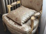 a chair that has a pillow on it in front of a window