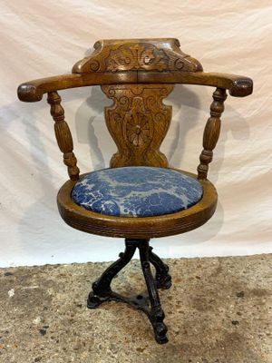 an old wooden chair with a blue cushion on top of it
