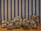 a table with a lot of tea and coffee cups and saucers