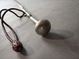 a necklace that has a ball on it on a table