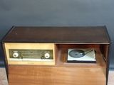 an old radio sitting on top of a wooden table