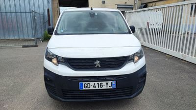 la petite camionnette blanche est garée devant un bâtiment