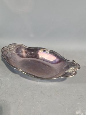 une assiette en argent sur laquelle est posée une coquille en argent