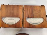two wooden clocks on a table with a white background