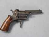 an old revolver with a wooden handle on a white surface