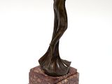 a bronze statue of a woman holding a vase on a marble base