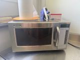 a microwave that is sitting on a counter with a roll of toilet paper on top of it