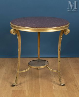 une table d'appoint avec un plateau en marbre doré et violet, posée sur un parquet