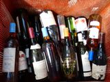 plusieurs bouteilles de vin dans un panier posé sur la table