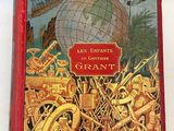 un vieux livre rouge sur lequel figure l'image d'un globe terrestre