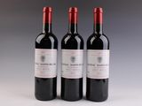 trois bouteilles de vin rouge posées côte à côte sur une table