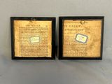 two framed books are sitting on a table next to each other