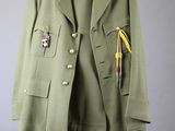 an army green jacket with a badge on the chest and a tie