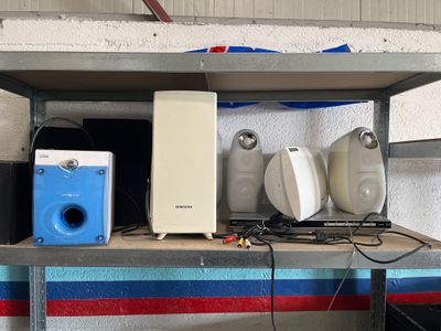 une étagère sur laquelle sont posés des haut-parleurs, des enceintes et d'autres appareils électroniques
