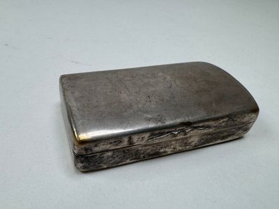 an old silver cigarette case sitting on top of a white table