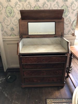 a dresser with a mirror on top of it in a room