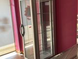 a refrigerator in the middle of a room with a pink wall