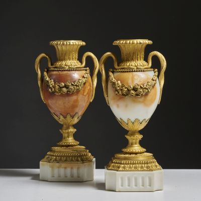 une paire de vases dorés et blancs posés sur une table blanche