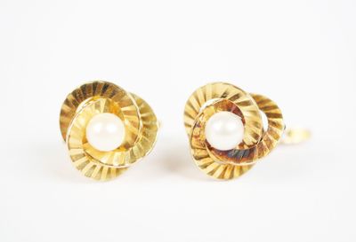 a pair of gold and pearl earrings on a white background