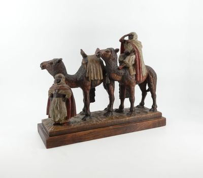 an image of a figurine of three people riding on camels