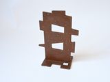 une petite sculpture en métal posée sur une surface blanche