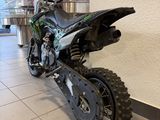 a dirt bike parked in a showroom near a wall