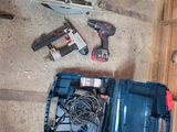 une boîte à outils contenant des outils, posée par terre à côté de lui