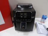 a coffee machine sitting on a table next to a red picture frame