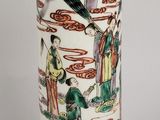 un vase blanc orné d'un motif représentant des personnes et des oiseaux