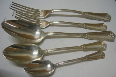 cinq cuillères en argent et deux cuillères en argent sur une table